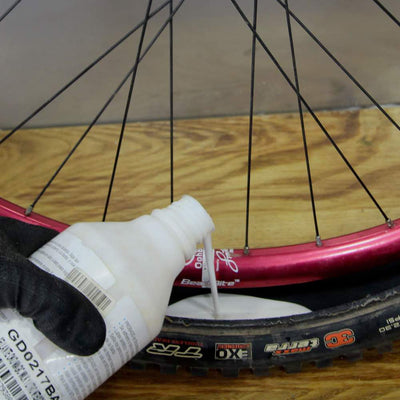 vertido de liquido sellante tubeless (latex sintetico) para neumatico de bicicleta, realizado a bordo de taller movil Chum