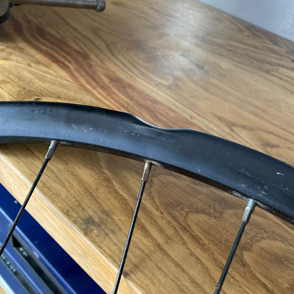 llanta de bicicleta de montaña con daño por  impacto, reparandose en taller movil chum