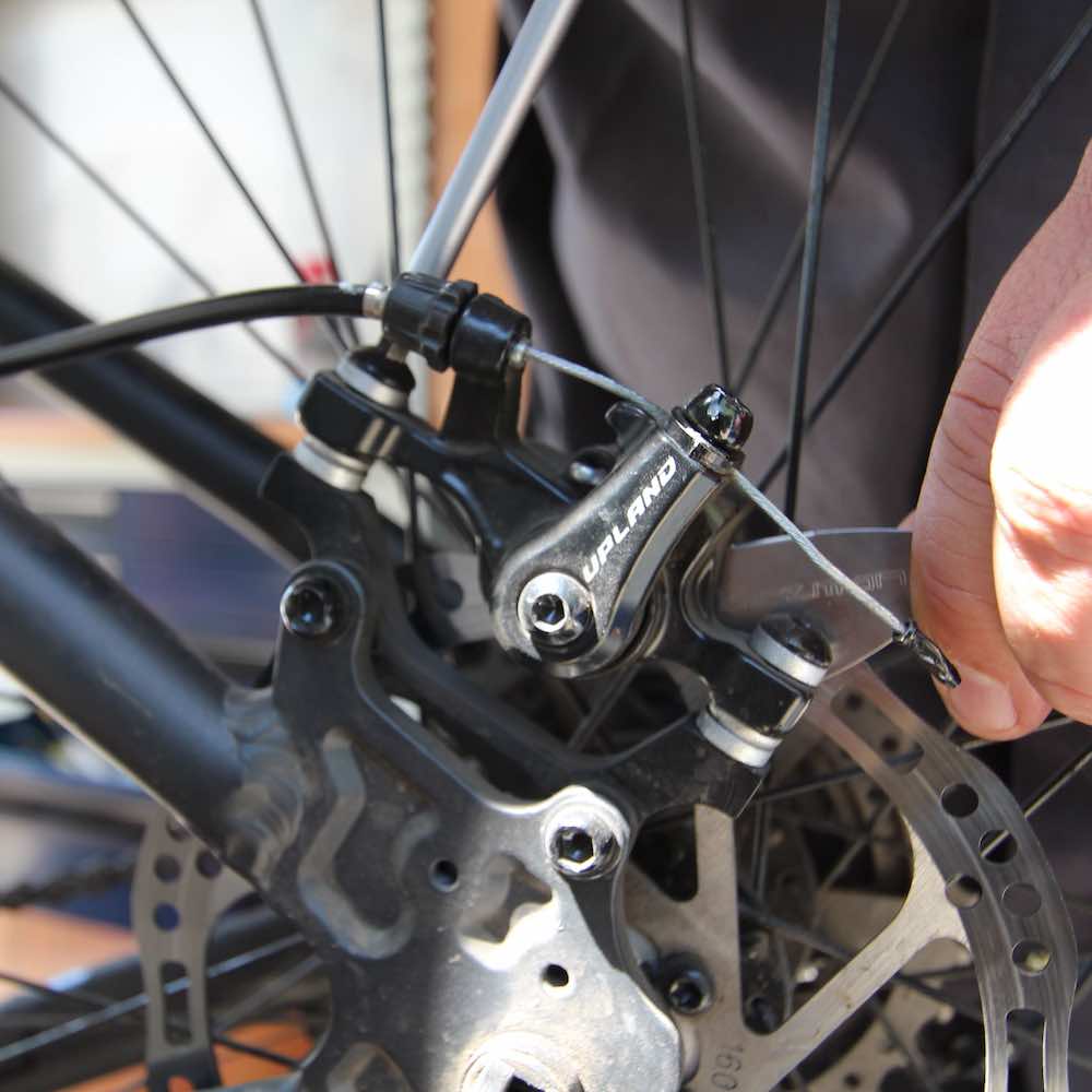 regulacion de posicion de caliper de freno mecanico de bicicleta , realizado durante mantención en taller movil chum