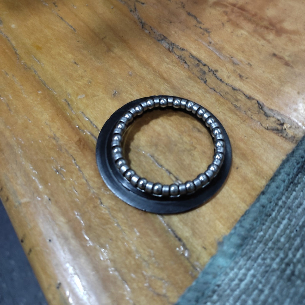 detalle de canastillo y sello de juego de direccion de bicicleta durante servicio a bordo de taller movil chum